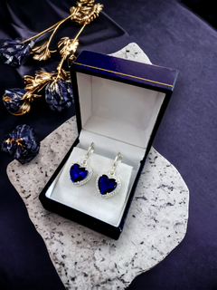 Aros de plata con cristales Swarovski en forma de corazón azul, presentados en una caja elegante.