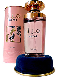 Frasco de perfume Mayar de Lattafa con tapa dorada, sobre una base azul, acompañado de su estuche decorativo en tonos rosa y detalles en verde.