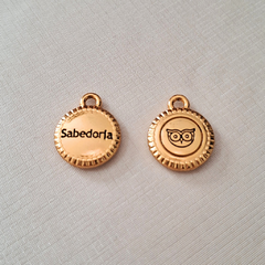 Medalha dourada com a inscrição "Sabedoria" de um lado e um desenho de coruja do outro lado.