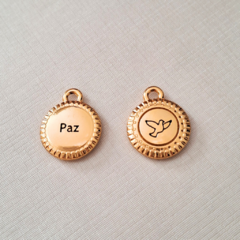 Medalha dourada com a palavra 'Paz' em uma face e o desenho de um pombo na outra.