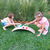 niñas jugando con la tabla curva Montessori como rampa para autos