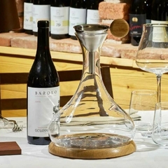 Uma decanter de vinho da marca italiana Legnoart ao lado de uma taça de vinho