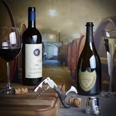 um saca-rolhas abridor de vinhos em cima de uma mesa com garrafas de vinho 