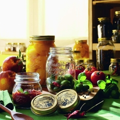 Uma mesa com potes de vidro bormioli rocco cheios de frutas e legumes