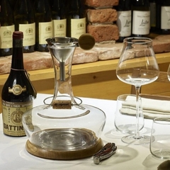 Uma mesa com taças, garrafa e decanter de vinho