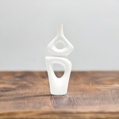 um vaso decorativo de cerâmica branca em formato orgânico em cima de uma mesa de madeira