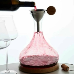 uma garrafa enchendo um decanter de vinho e duas taças