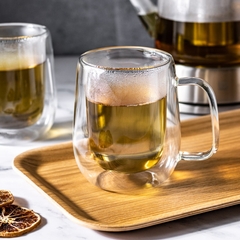 caneca de vidro duplo, com chá, sobre uma mesa