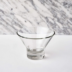 uma taça de vidro para sobremesa em cima de uma mesa branca