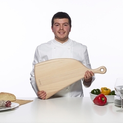 um homem vestido de chef de cozinha segurando uma tábua de corte de madeira de faia, importada da itália da marca Legnoart