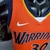 Camiseta regata laranja do Golden State Warriors, modelo masculino da Nike, com detalhes em azul e logo da marca.