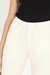 Calça jeans skinny off-white de cintura alta e botões de pressão forrados, foto frontal com foco nos detalhes dos botões forrados do produto.