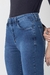 Calça jeans flare acetinada azul médio foto frontal com foco nos detalhes dos botões de pressão forrados.
