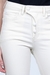 Calça Flare Off-white de cintura alta e botões forrados, foto frontal com foco nos detalhes dos botões do produto.