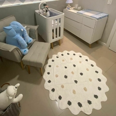 tapete infantil redondo polka dots branco com bolinhas cinza e cru em um quarto de bebê com berço e poltrona ao fundo