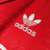 Detalhe do logo da Adidas em uma camisa vermelha retro do Manchester United de 1990.