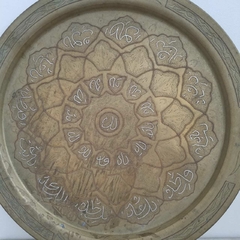 Grande prato em metal dourado com desenho cental de uma flor de lótus com escritas árabes na internet