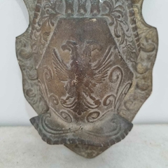 Antigo escudo com brasão, com espada e machado na internet