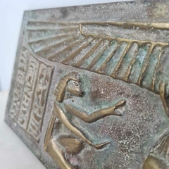 Relíquia decorativa de inspiração egípcia com hieróglifos e divindades