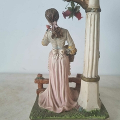 Belíssima peça representando mulher florista ao lado de poste de iluminação - loja online