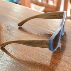 anteojos de sol de madera (patillas) y acetato color azul traslucido (frente) con lentes color marrón modelo Los Angeles marca Nómade vista perfil derecho