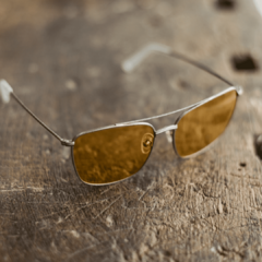 anteojos de metal color plata de forma rectangular con frente y barral con lentes tintados color ambar modelo La Juanita marca Nómade