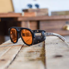 Anteojos de sol de madera (patillas), acetato color negro terminación mate (frente) y cuero (apliques laterales) con lentes color anaranjado vista perfil modelo Roma ADV marca Nómade