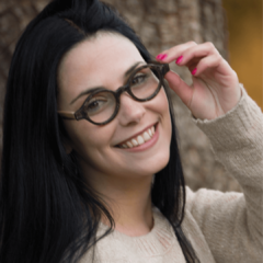 Mujer luciendo anteojos de madera (patillas) y acetato (frente) color simil nacar con forma redondeada para lentes de aumento modelo Liverpool marca Nomade  ( vista de frente)
