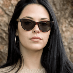 mujer luciendo anteojos de sol de madera (patillas) y acetato (frente) con lentes polarizados. Estilo cateyes marca Nomade