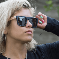 Mujer luciendo anteojos de sol de madera (patillas) y acetato (frente) con lentes polarizados modelo Milan-marca Nómade vista perfil