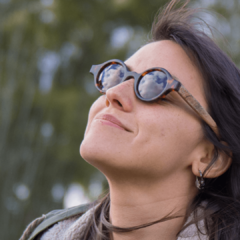 mujer con anteojos de madera y acetato tipo carey modelo Liverpool marca Nómade. Gafas de sol redondas de tamaño pequeño