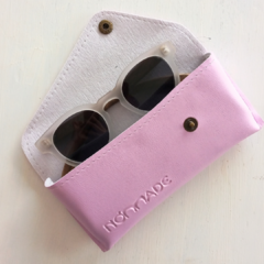 estuche para anteojos de cuero sintetico color lila con cierre de boton marca Nomade abierto con anteojos de sol en su interior  fondo blanco