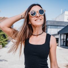 Modelo femenina sonriendo mientras usa anteojos de sol de madera y acetato Anthony.