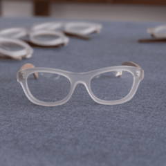 anteojos de madera (patillas) y acetato (frente) color cristal traslúcido de forma rectangular para colocar lentes de aumento modelo Paris marca Nómade (vista de frente)