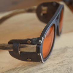 Anteojos de sol de madera (patillas), acetato color negro terminación mate (frente) y cuero (apliques laterales) con lentes color anaranjado vista detalle del talon modelo Roma ADV marca Nómade