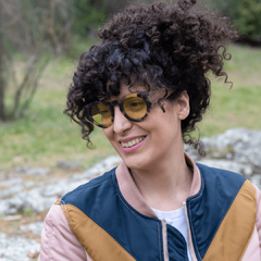 mujer con anteojos de madera (patillas) y acetato (frente) simil carey con lentes color amarillo, forma redonda, estilo oversized modelo Skorpios TINT marca Nomade vista perfil izquierdo