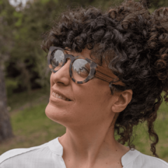 mujer con anteojos de madera (patillas) y acetato (frente) simil carey con forma redonda modelo Skorpios marca Nomade vista perfil izquierdo