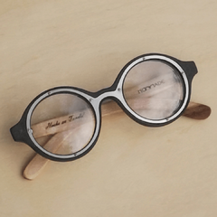 anteojos de madera (patillas) y acetato (frente) color negro de forma redondeada para colocar lentes de aumento modelo Sondrio marca Nómade ( vista de frente)