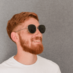 hombre joven de piel blanca y pelo rojo con anteojos de sol de metal color plata de forma redonda con lentes color gris modelo Los Pioneros marca Nomade