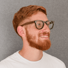 hombre joven de piel blanca y pelo rojo con anteojos de forma redondeada color verde con aplique de acero y patillas de madera modelo Dublin marca Nomade