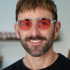 hombre con anteojos de madera (patillas) y acetato (frente) color cristal estilo oversized con lentes tintados color rojo categoría 2 modelo Elton marca Nomade 
