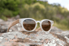 anteojos de madera (patillas) y acetato (frente) color cristal de forma redondeada con lentes de sol polarizados modelo Chalten marca Nómade (vista inclinada lado derecho del anteojo)