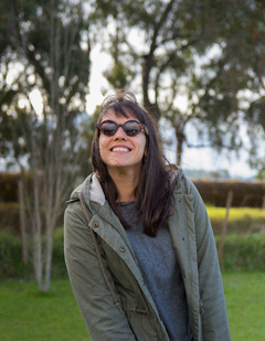 mujer con anteojos de madera y acetato color negro modelo Liverpool marca Nómade. Gafas de sol redondas de tamaño pequeño