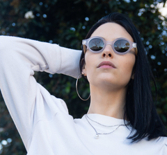 mujer con anteojos de madera y acetato cristal traslúcido modelo Liverpool marca Nómade. Gafas de sol redondas de tamaño pequeño