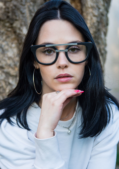 mujer con anteojos de madera (patillas), acetato (frente) color negro y puente de acero inoxidable para colocar lentes de aumento modelo Ankara marca Nómade