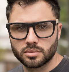 hombre con anteojos de madera (patillas) y acetato color negro mate (frente) para colocar lentes de aumento de forma rectangular modelo Tulum marca Nómade