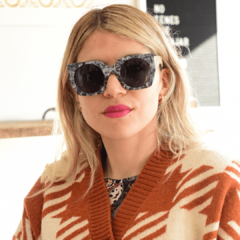 mujer joven de pelo rubio con anteojos de sol estilo oversized color blanco y negro en el frente modelo Leblon marca Nomade con fondo neutro