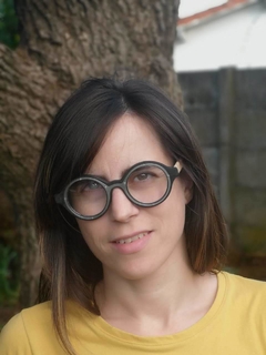 Mujer con anteojos de madera (patillas) y acetato (frente) color negro de forma redondeada para colocar lentes de aumento modelo Sondrio marca Nómade