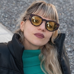 mujer con con anteojos de madera (patillas) y acetato (frente) simil carey con lentes color amarillo, forma redonda, estilo oversized modelo Skorpios TINT marca Nomade