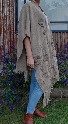 Ruana de lana de llama color arena tejida en telar y bordada con motivos florales en internet
